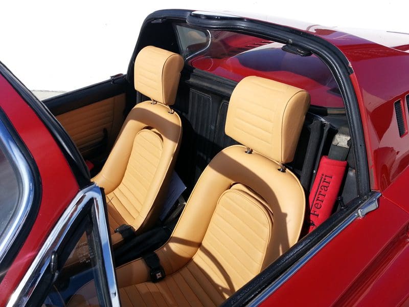 Luxurious beige leather seats inside a red convertible car.