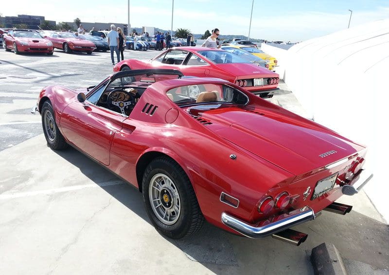 Classic red sports car parked outdoors on a sunny day.