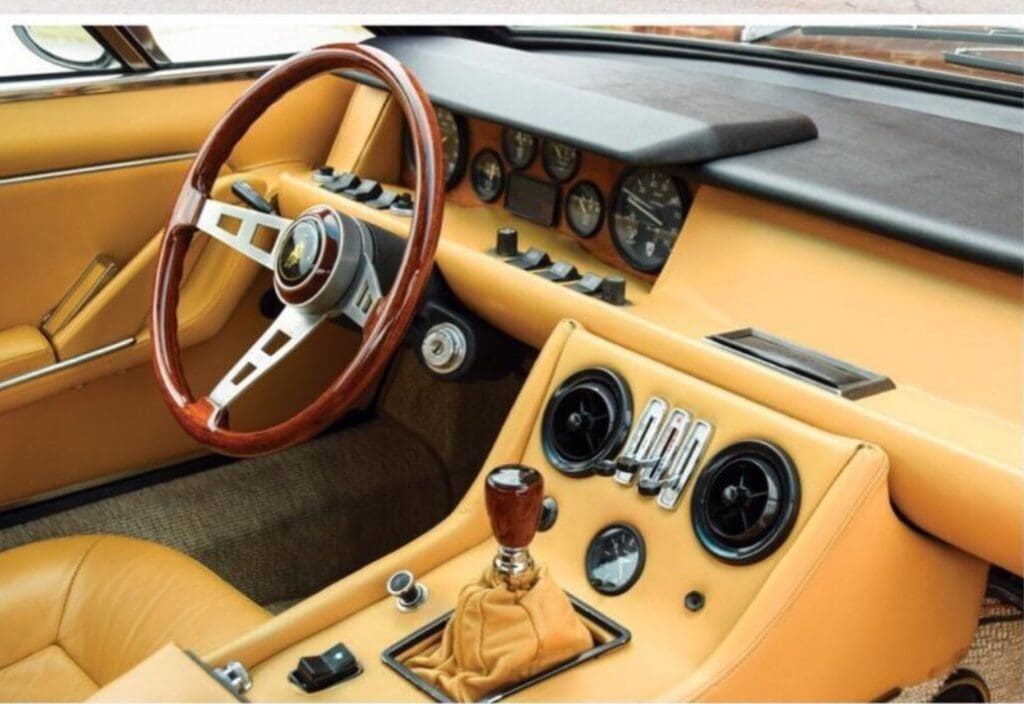 Classic car interior with wooden steering wheel and beige dashboard.