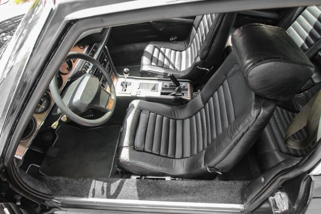 Interior view of a sleek black sports car with leather seats.