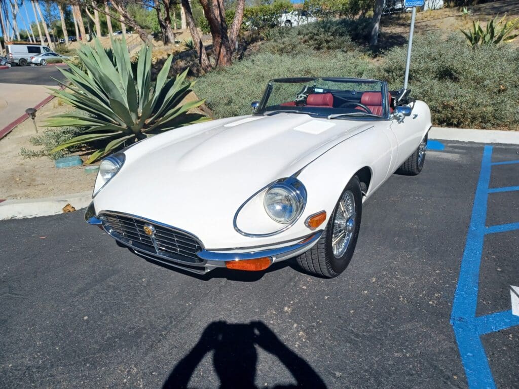 Classic white convertible vintage car parked on driveway.