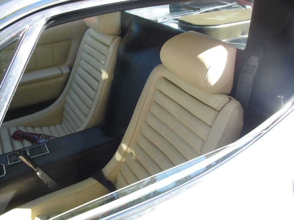 Interior view of a car showing beige leather seats with horizontal stitching.
