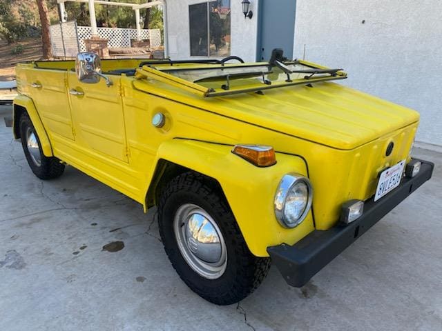 Yellow vintage off-road vehicle parked outdoors.