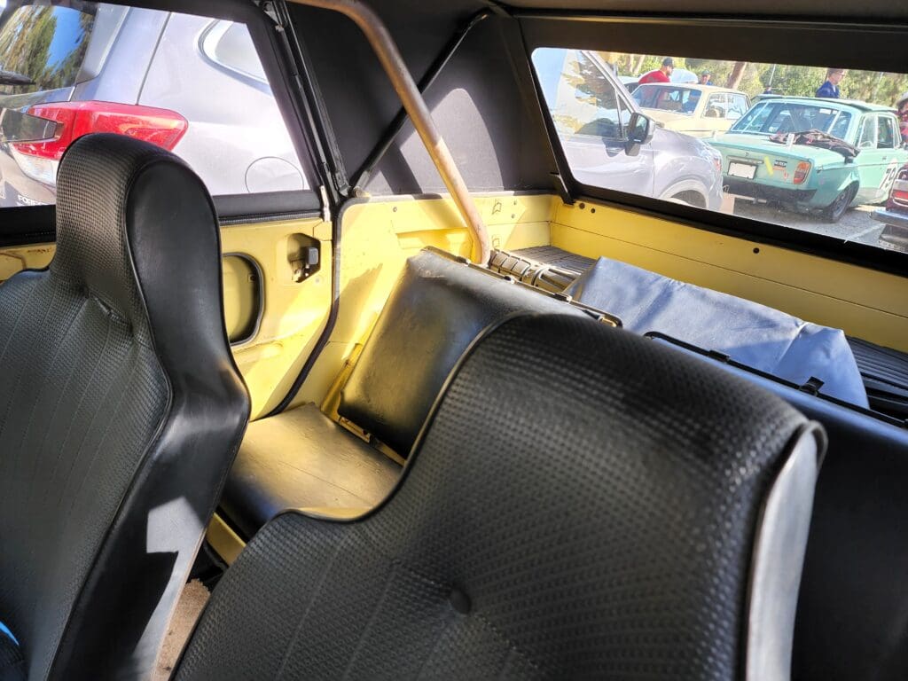 Interior view of a compact car showing black seats and yellow accents.