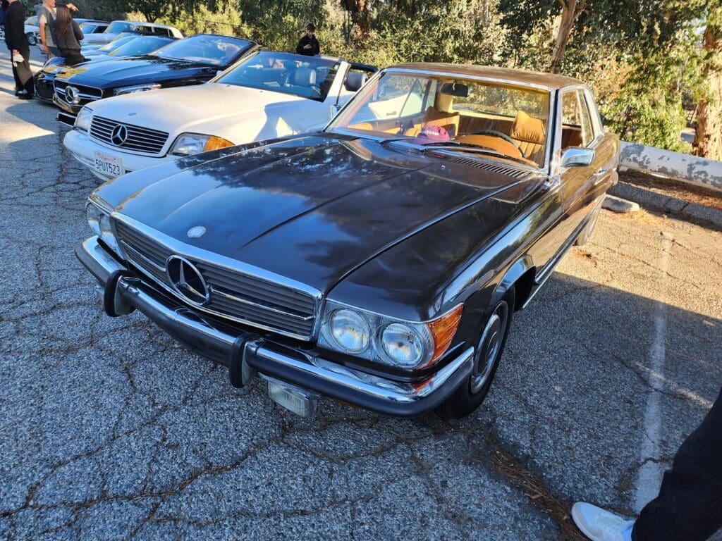 Classic black Mercedes-Benz convertible parked outdoors on a sunny day.