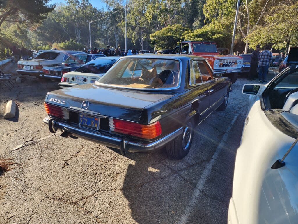 Classic black Mercedes-Benz convertible parked outdoors on a sunny day.