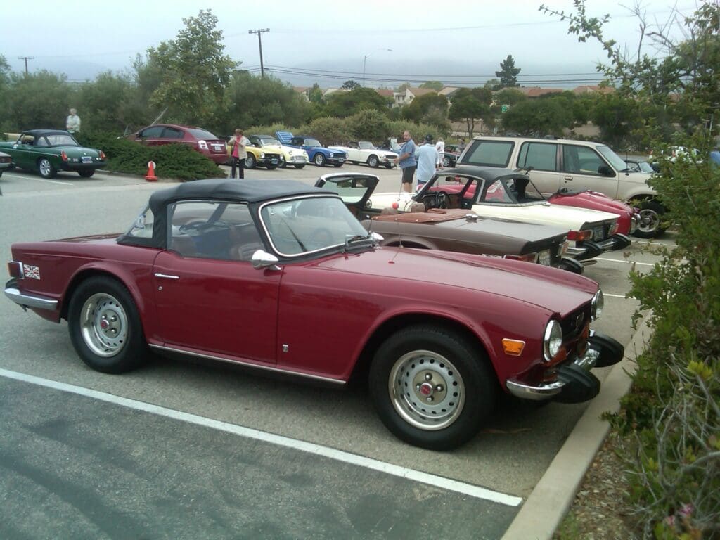 Classic red convertible car parked in a lot.