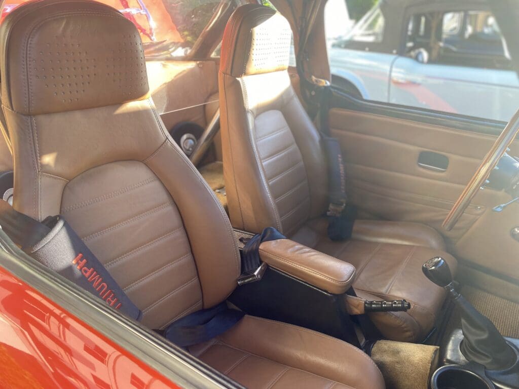 Interior of a car with brown leather seats and a center armrest.