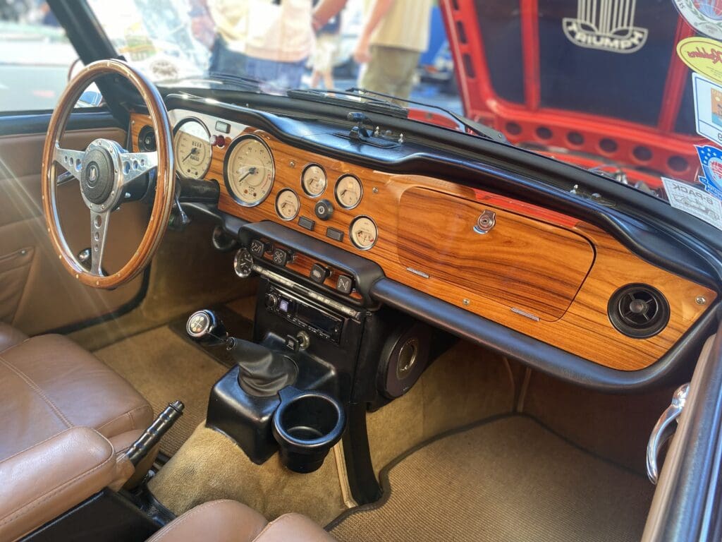 Classic car dashboard with wooden trim and vintage gauges.