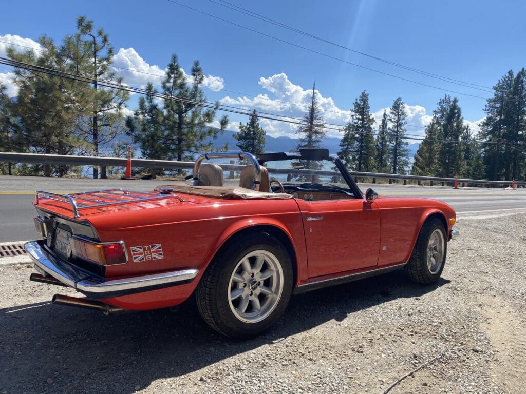 Classic red convertible sports car parked on a sunny day.