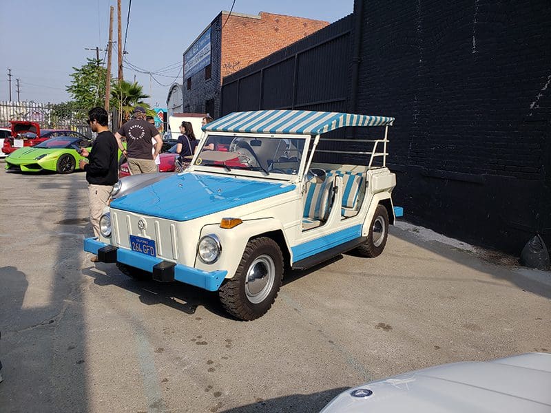 Vintage blue and white off-road vehicle parked on a sunny street.
