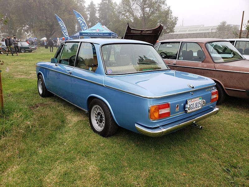 Classic blue Volvo car parked on grass at a car show.