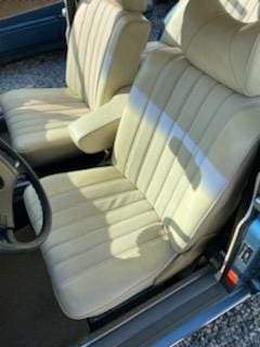 Close-up of beige leather car seats inside a vehicle.