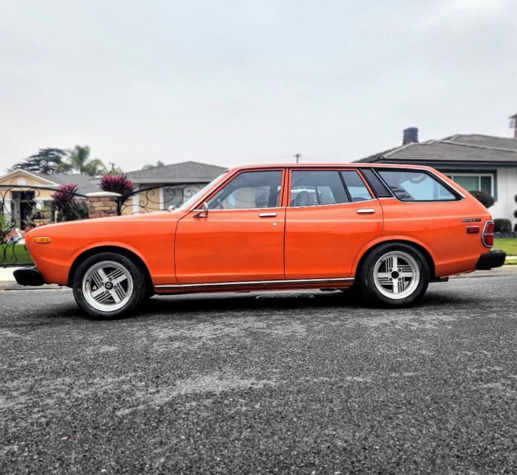 Orange vintage station wagon parked on a suburban street.