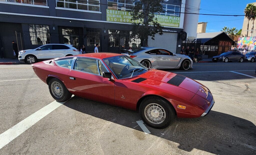 Red vintage sports car parked outdoors on a sunny day.