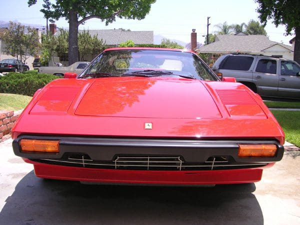 Red convertible sports car parked outdoors on a sunny day.