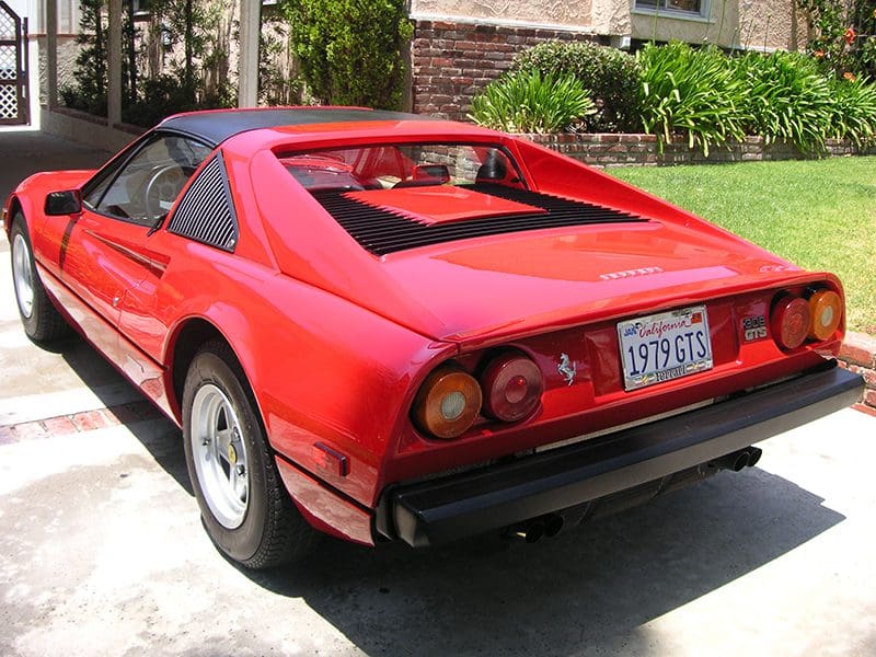 Red convertible sports car parked outdoors on a sunny day.