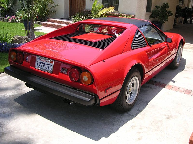 Red convertible sports car parked outdoors on a sunny day.