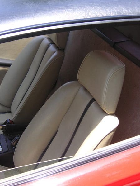 Close-up of beige leather car seats inside a vehicle.