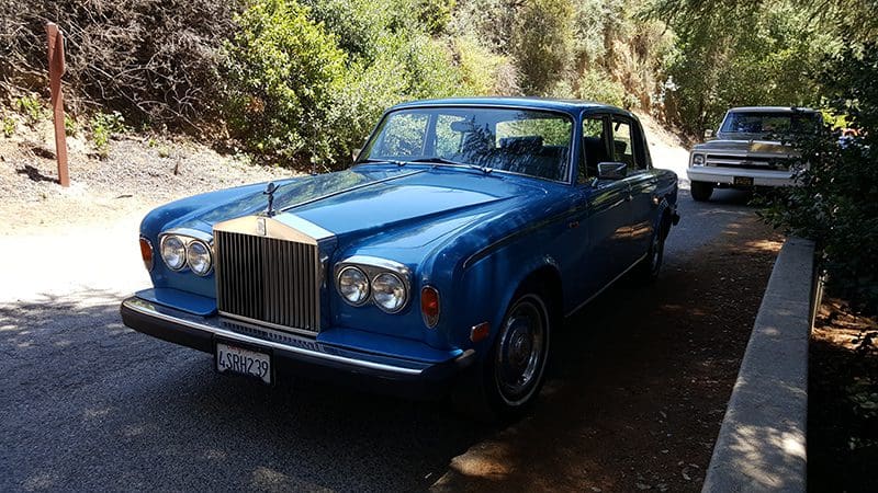 Classic blue Rolls-Royce convertible parked outdoors.