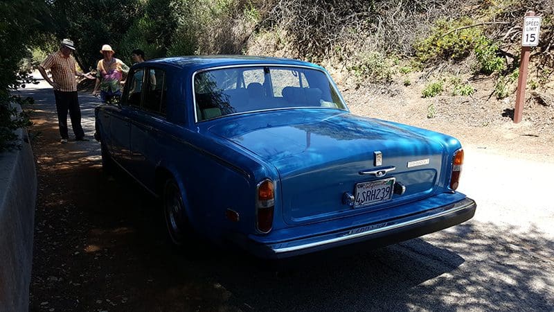Classic blue Rolls-Royce convertible parked outdoors.