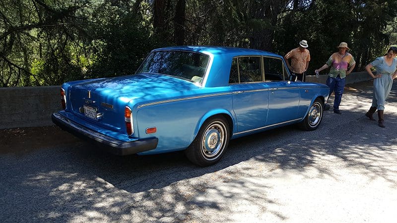 Classic blue Rolls-Royce convertible parked outdoors.
