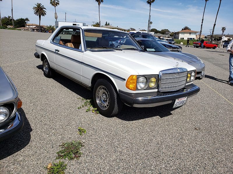 Classic white Mercedes-Benz coupe parked outdoors on a sunny day.