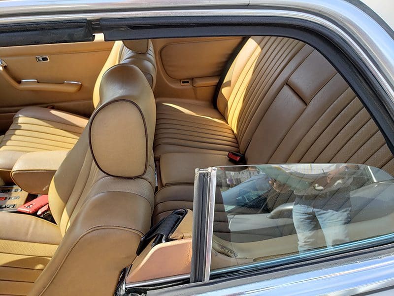 Vintage car interior featuring tan leather seats and classic design.