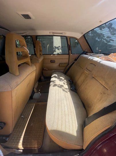 Interior of a vintage car with brown and beige seats.