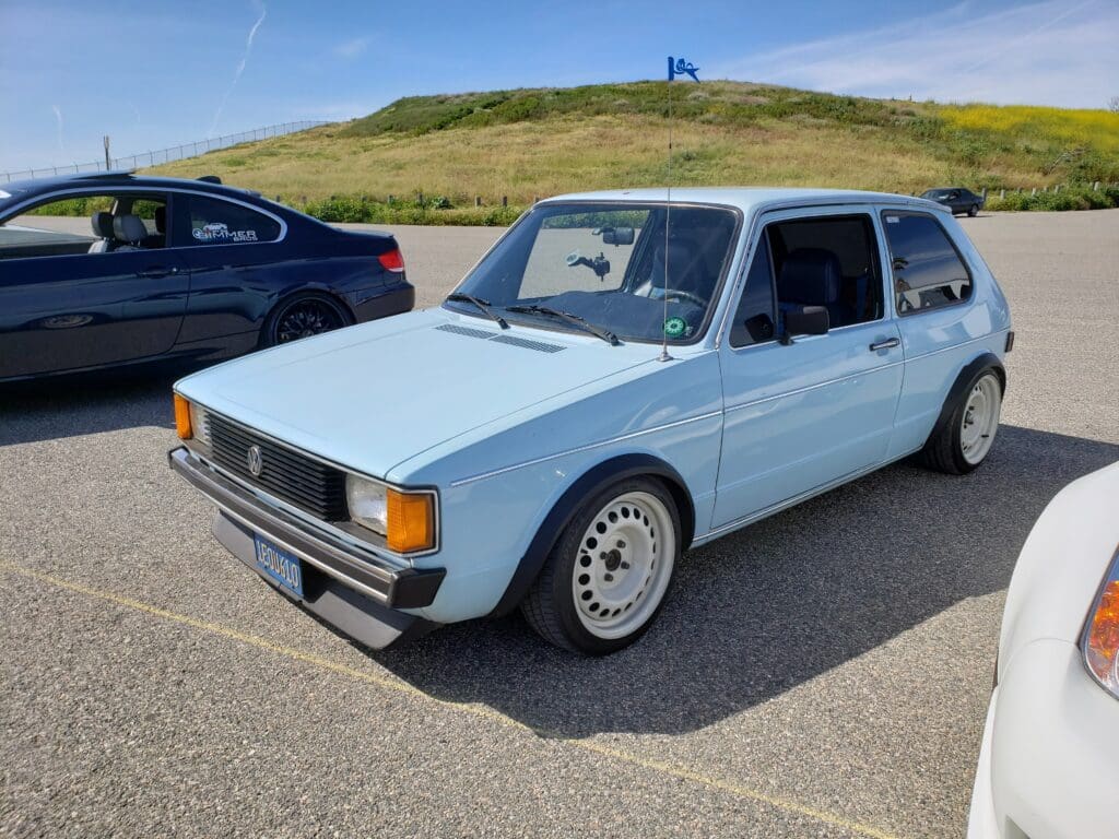 Classic light blue Volkswagen Golf parked outdoors on a sunny day.