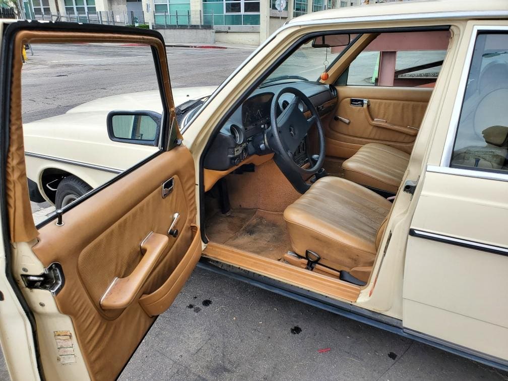 Vintage car interior with tan leather seats and classic design.