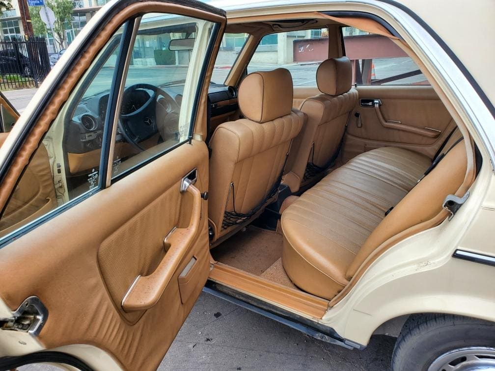 Vintage car interior featuring tan leather seats and classic design.
