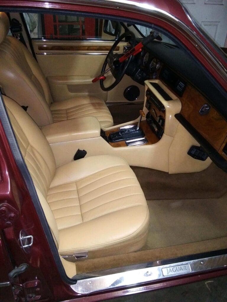 Luxurious beige leather interior of a classic car with wood trim.