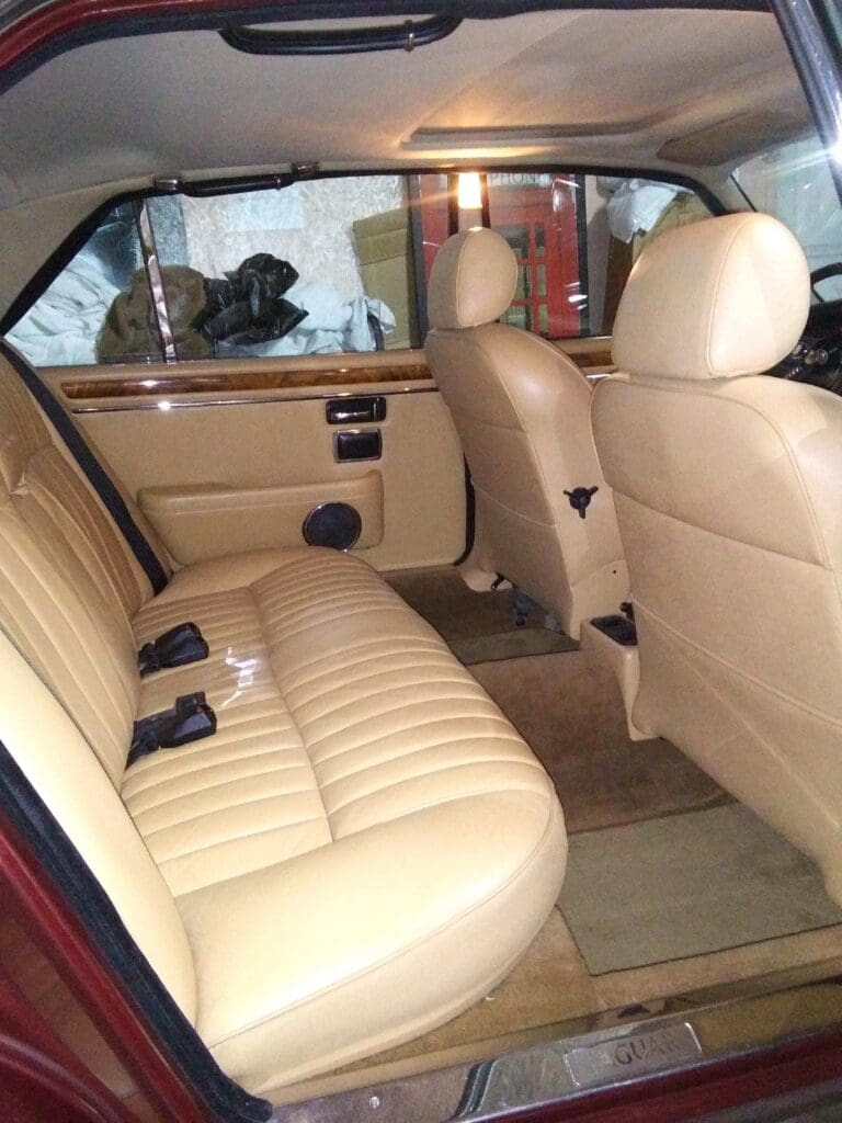 Interior view of a car with beige leather seats and spacious legroom.