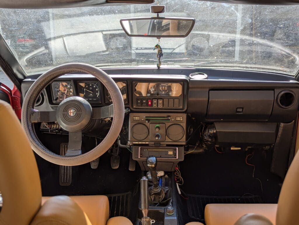 Classic car interior with vintage steering wheel and dashboard.