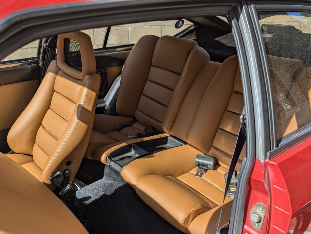Luxurious tan leather rear seats inside a vintage car.