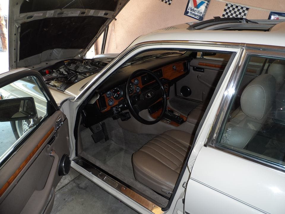 Interior view of a classic car with beige seats and detailed dashboard.