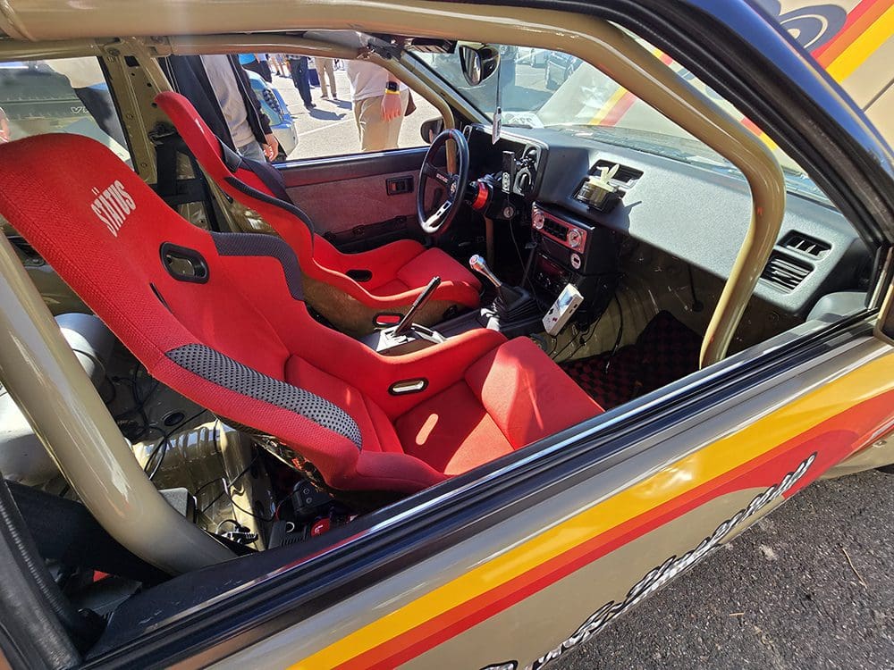 Interior of a car with red racing seats and a sporty setup.