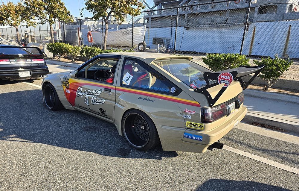 A vintage racing car with a wide body kit and large rear wing.