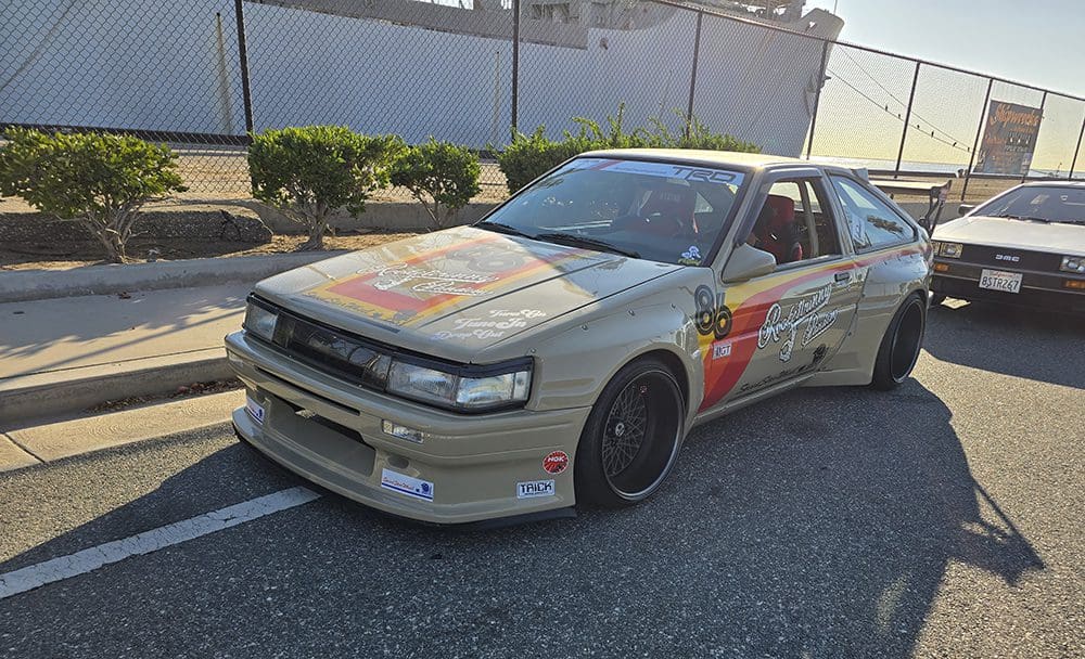A vintage sports car with custom decals parked on the street.