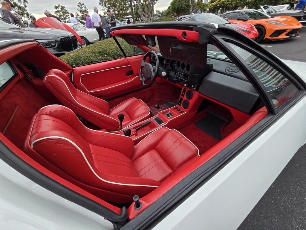 Luxurious red leather interior of a convertible sports car with modern controls.
