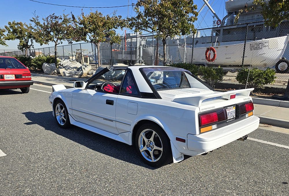 White convertible sports car parked outdoors on a sunny day.