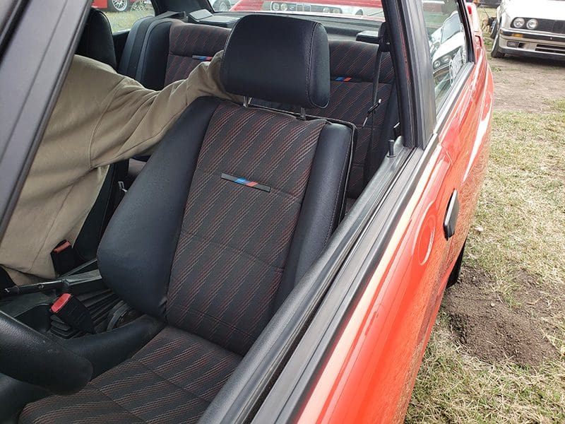 Interior view of a vintage car with a plaid seat cover.