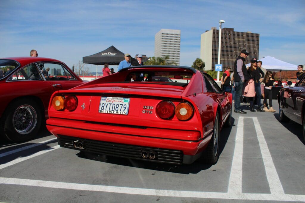 Red Ferrari sports car parked outdoors during an event.