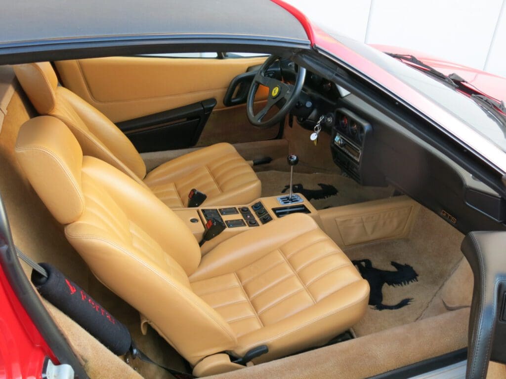 Interior of a vintage car with tan leather seats and classic dashboard.