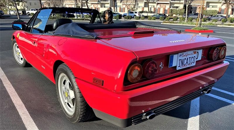 Rear view of a red vintage convertible sports car parked outdoors.