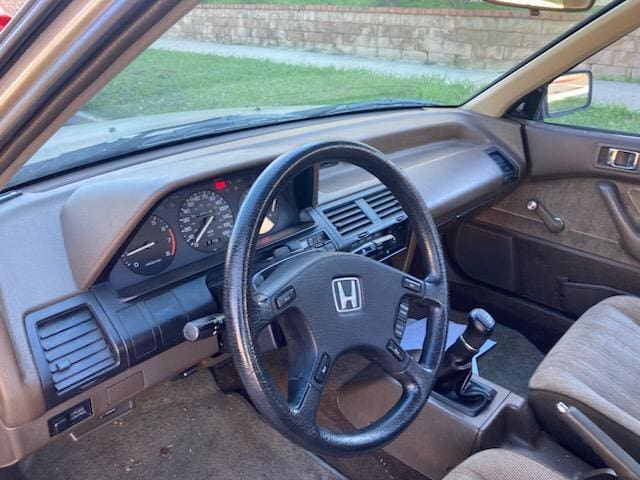 Interior view of an older Honda car with a manual transmission.