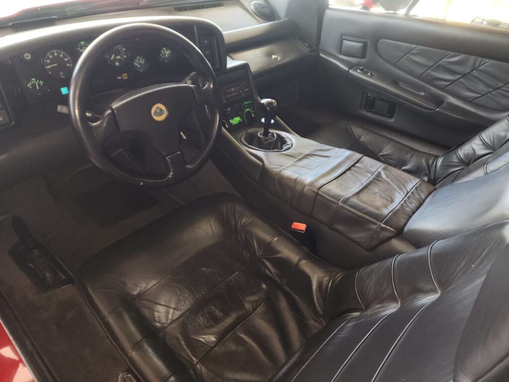 Interior of a black leather classic sports car with manual transmission.