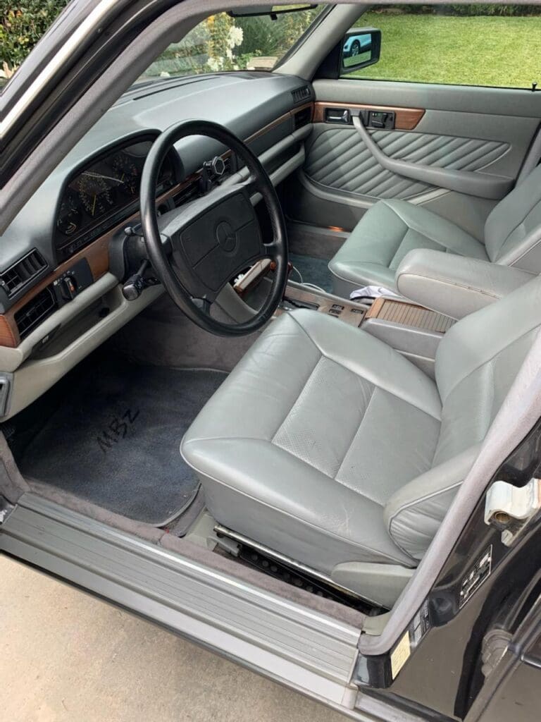 Luxurious gray leather interior of a car with wood trim accents.