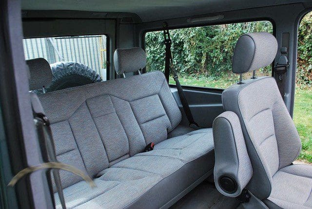 Interior of a car showing rear and front seats with gray upholstery.